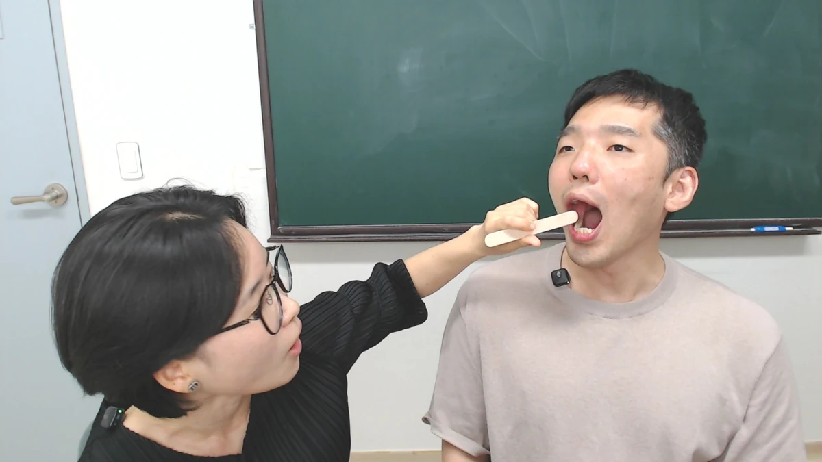 설압자로 기역 소리를 유도하는 방법을 직접 시연하는 장면